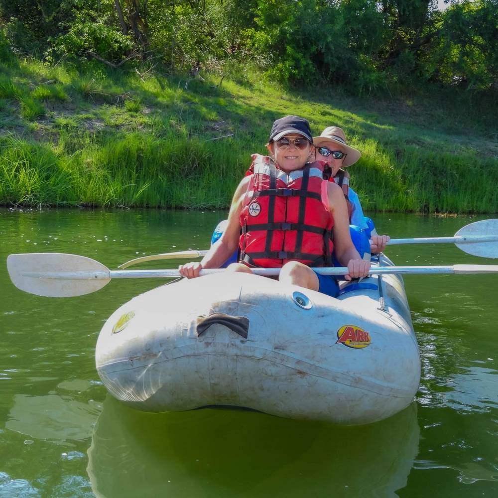 Two guests smiling from a canoe