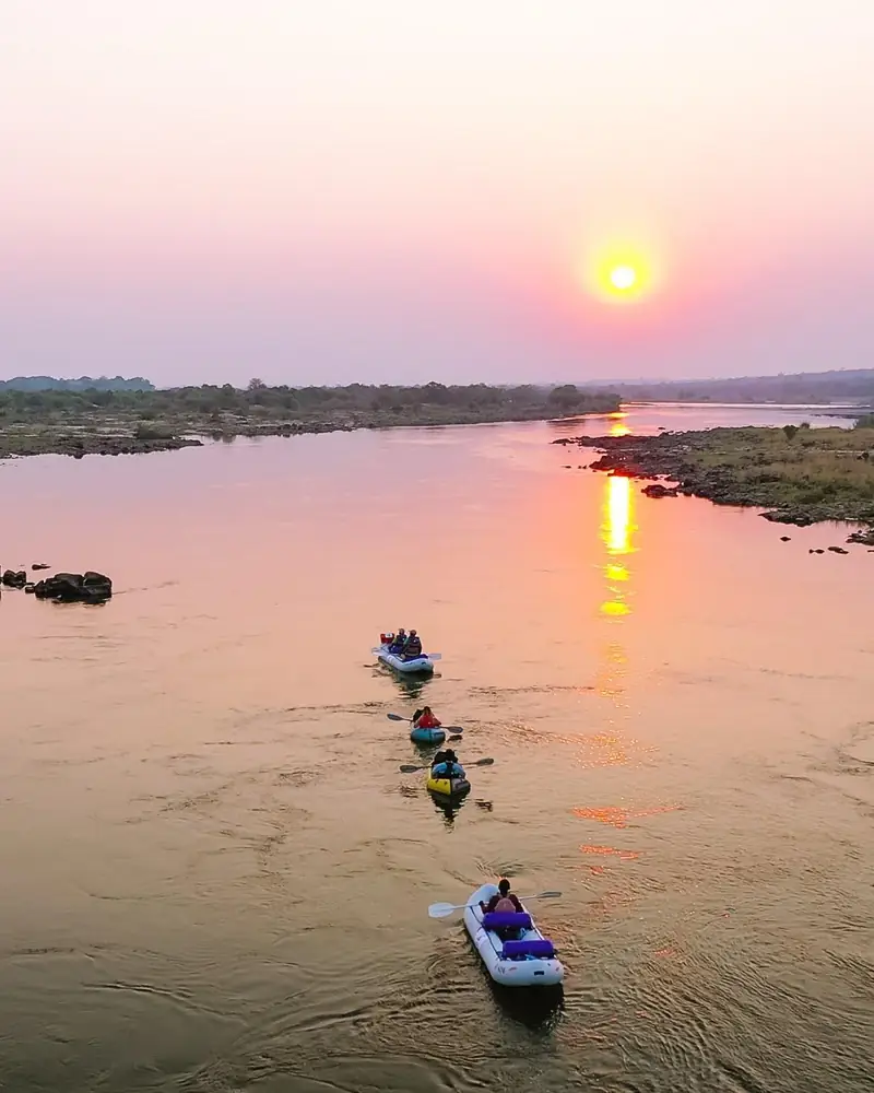 Canoes paddling the Upper Zambezi at sunset